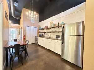 a kitchen with a table and a stainless steel refrigerator at Haven at Hazel Downtown Loft in Demorest