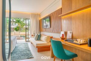 a living room with a couch and a table with a chair at île de Pipa - Ma Plage Hotel in Pipa