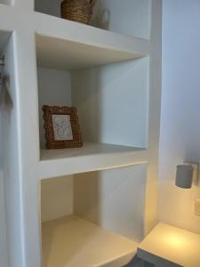 a white shelf with a clock sitting on it at Aegean Breeze in DYO CHORIA TINOS in Triandáros