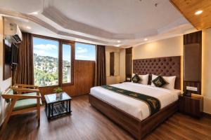 a bedroom with a large bed and a large window at Anandam Near Mall Road in Shimla