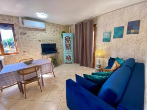 a living room with a blue couch and a table at Domaine Ô Clair de Lune - Chambres d'Hôtes et Gîtes à Sarlat - Accès Cité Médiévale 5 minutes à pied - Parking - SPA & Massages en option - Piscine de saison in Sarlat-la-Canéda