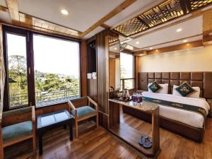 a room with a bed and a desk and a window at Anandam Near Mall Road in Shimla
