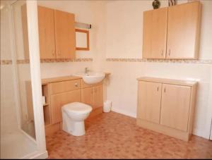 a bathroom with a toilet and a sink at Ben Alder Spacious 3 Bedroom House in Orkney +2 photos