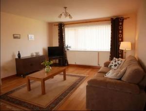 a living room with a couch and a coffee table at Ben Alder Spacious 3 Bedroom House in Orkney