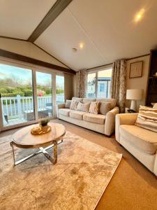 a living room with two couches and a table at Archerfield Luxe Lodge in Port Seton