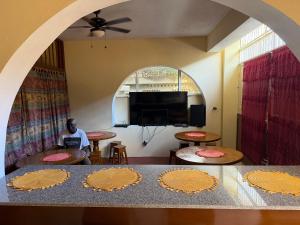 a man sitting in a room with a table with plates on it at La Belle Maison Milot in Samson