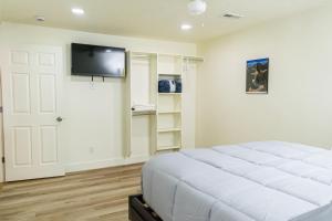 a bedroom with a white bed and a flat screen tv at Duchesne River LLC in Duchesne