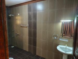 a bathroom with a shower with a sink and a toilet at Ocean Breeze Nook in Mombasa