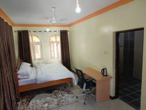 a bedroom with a bed and a desk and a deskablish at Ocean Breeze Nook in Mombasa
