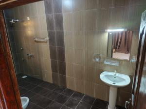 a bathroom with a sink and a shower with a mirror at Ocean Breeze Nook in Mombasa