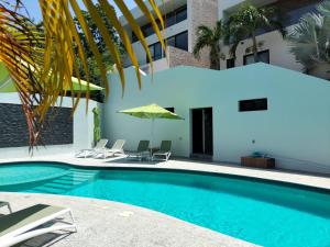 a swimming pool with chairs and a building at Condo arrosito village in Tangolunda