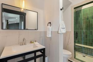 a bathroom with a sink and a mirror and a toilet at Superior King Room at The Emerald in Beaufort