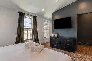a bedroom with a bed with two towels on it at Superior King Room at The Emerald in Beaufort