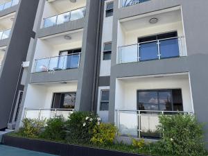a facade of a building with balconies and bushes at Nessie Homes in Nairobi