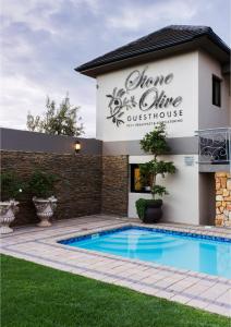 a villa with a swimming pool in front of a building at Stone Olive in Jeffreys Bay