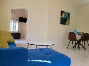 a living room with a blue couch and a table at Home Escape Negril Unit 3 in Negril