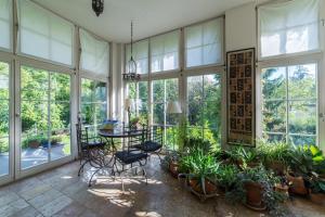 um jardim de Inverno com mesa, cadeiras e plantas em Embassy Row BnB em Zagreb