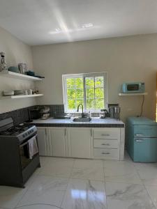 a kitchen with a sink and a window at Home Escape Negril Unit 3 in Negril