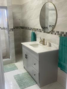 a bathroom with a sink and a mirror and a shower at Home Escape Negril Unit 3 in Negril +33 photos