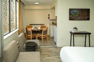 a room with a table and chairs and a kitchen at Hotel Opportune in Vancouver