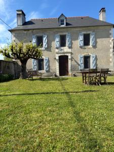 a large house with benches in front of it at Maison village entre pau et lourdes in Boeil-Bezing