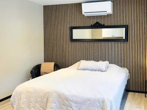 a bedroom with a bed and a mirror on the wall at 4 star holiday home in SÖLVESBORG in Sölvesborg