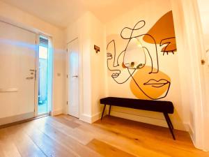 a room with a wall with a painting of a woman at Superb House Sleeps 7 parking in Cambridge in Trumpington
