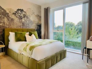 a bedroom with a bed with a large window at Superb House Sleeps 7 parking in Cambridge in Trumpington