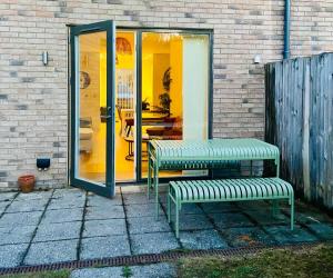 two benches sitting in front of a house at Superb House Sleeps 7 parking in Cambridge in Trumpington