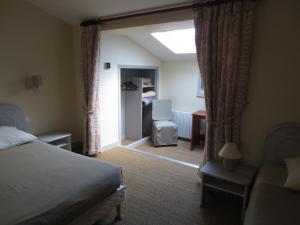 a bedroom with a bed and a chair and a window at Les Chambres du Phoebus in La Tremblade