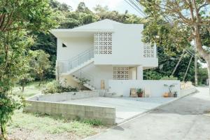a white house with stairs and trees at MANANI - Vacation STAY 16628v in Nago