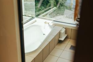 a bath tub in a bathroom with a window at MANANI - Vacation STAY 16628v in Nago