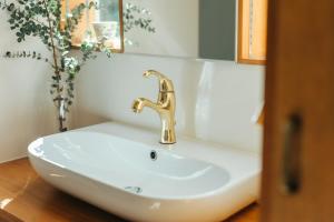 a white sink with a gold faucet in a bathroom at MANANI - Vacation STAY 16628v in Nago +14 photos