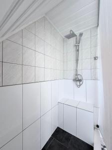 a bathroom with a shower with white tiles at KM APPARTS Wesel 6 in Wesel +22 photos