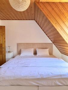 a bedroom with a large bed with a wooden ceiling at KM APPARTS Wesel 6 in Wesel