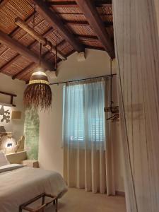 a bedroom with a bed and a large window at Masseria Petra in Martano