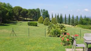 a park with a table and chairs in the grass at Villa Panconesi in Montespertoli