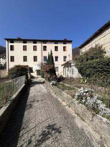 an empty street in front of a large white building at Papiria Residence in Piovene Rocchette