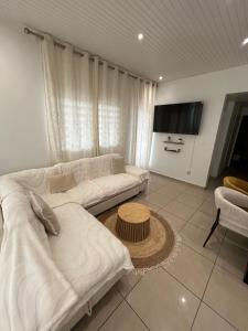 a living room with a white couch and a table at Le Papillon in Le Moule