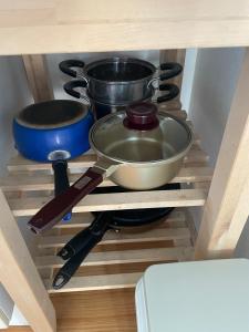 a shelf with cooking utensils and pans on it at ReFa room由来House in Kumamoto +11 photos