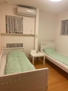 a hospital room with two beds and a table at ReFa room由来House in Kumamoto