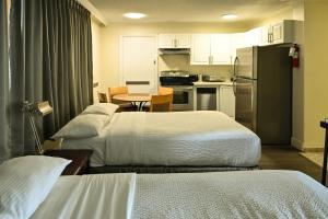 a room with two beds and a kitchen with a refrigerator at Hotel Opportune in Vancouver +28 photos