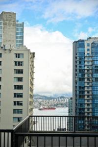 a view of a city with buildings and a boat in the water at Hotel Opportune in Vancouver