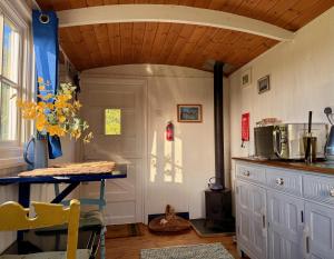 a kitchen with a counter and a table in a room at Shepherd's Hut near Oxford in Cumnor
