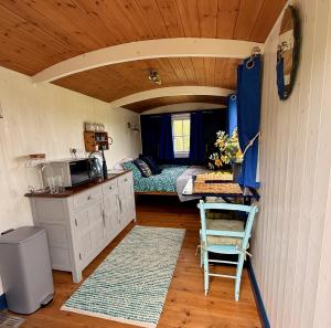 a room with a caravan with a bed and a kitchen at Shepherd's Hut near Oxford in Cumnor