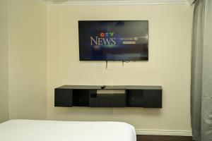 a flat screen tv hanging on a wall at Hotel Opportune in Vancouver