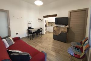 a living room with a couch and a table and a kitchen at B&B Baroi Orgosolo in Orgosolo
