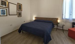 a bedroom with a bed with a blue blanket at B&B Baroi Orgosolo in Orgosolo