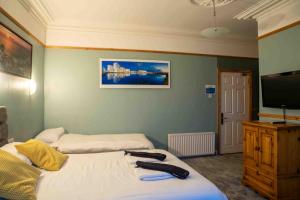 a bedroom with two beds and a flat screen tv at Harbour Heights B&B in Portrush