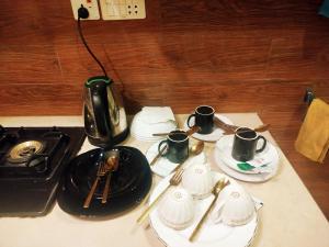 a table topped with black plates and cups and utensils at The Warmer House Islamabad Airport in Islamabad